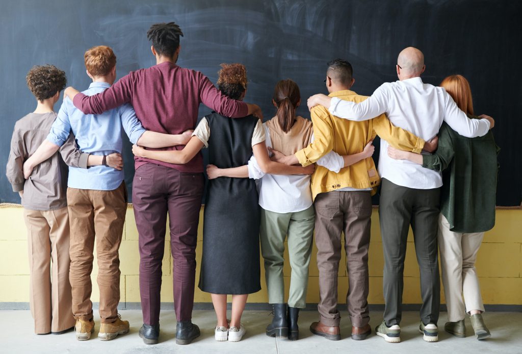 A group of people joined together facing a chalkboard