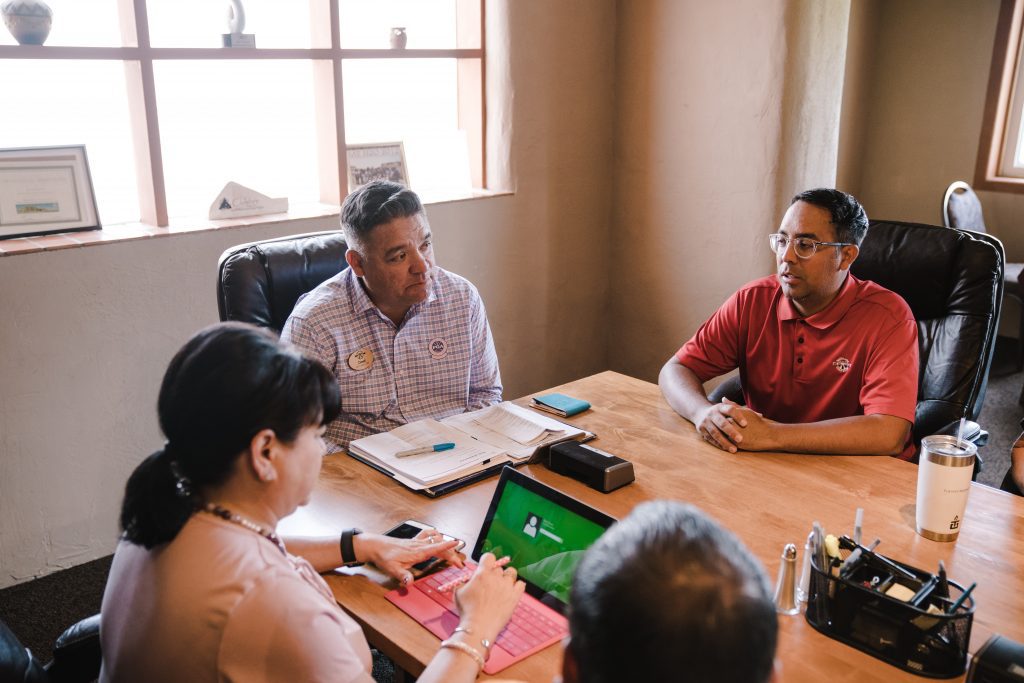 Three people sitting at a conference room table