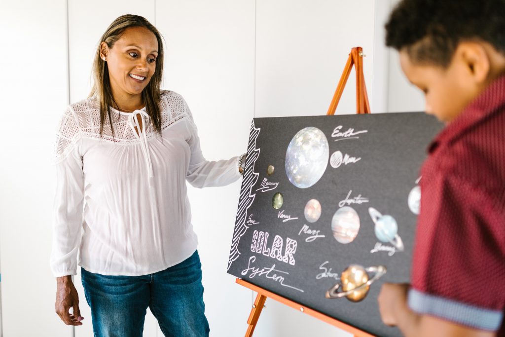 Teacher looking at a student's solar system 