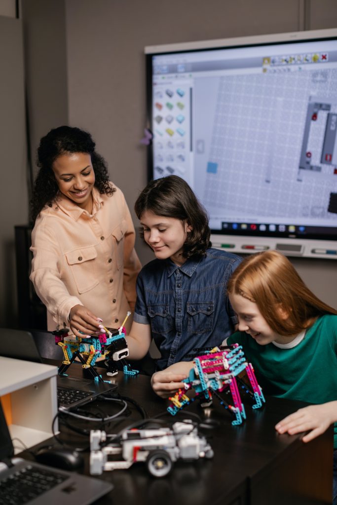 Teacher helping two students with a STEM-related activity