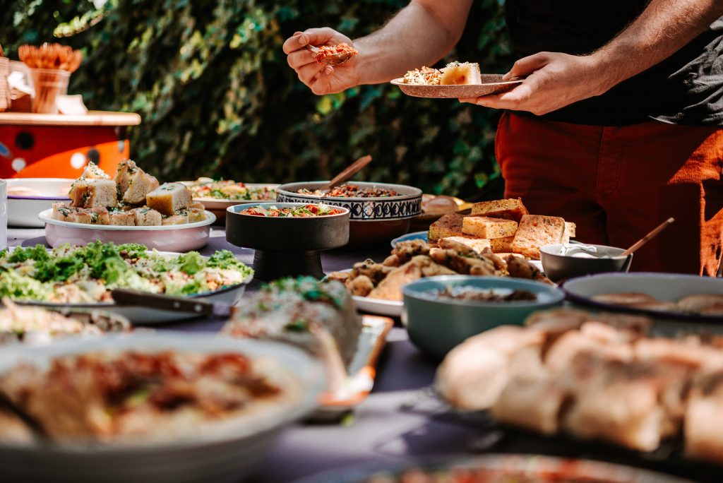Close up of person's hands filling plate at a buffet table