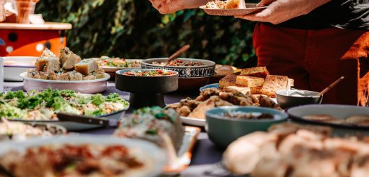 Close up of person's hands filling plate at a buffet table