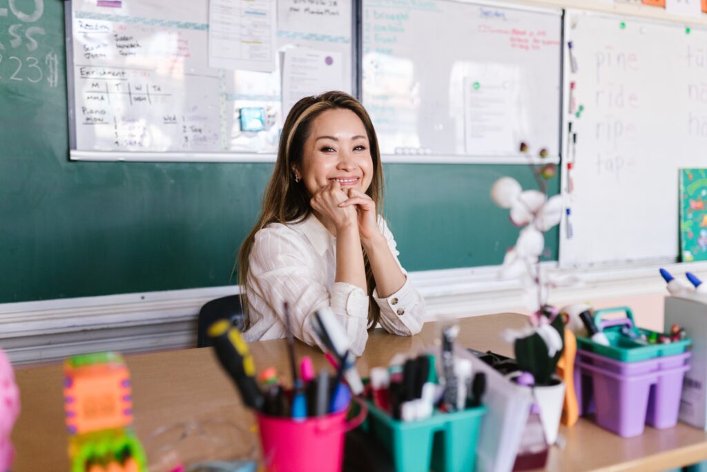 Photo of teacher sitting behind her desk smiling