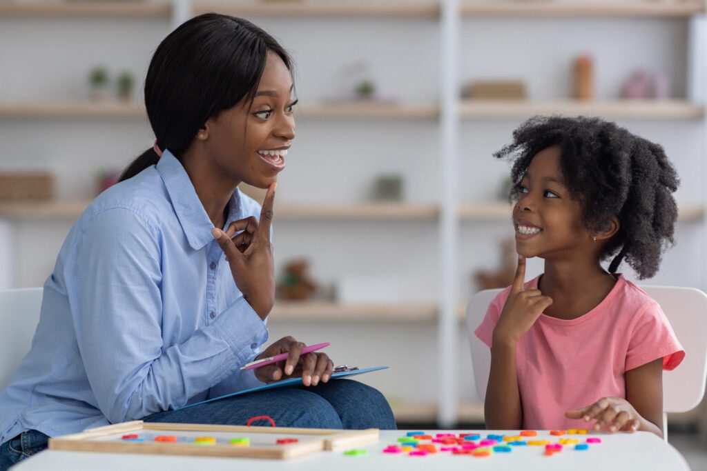 Speech therapist working with a young girl at a clinic